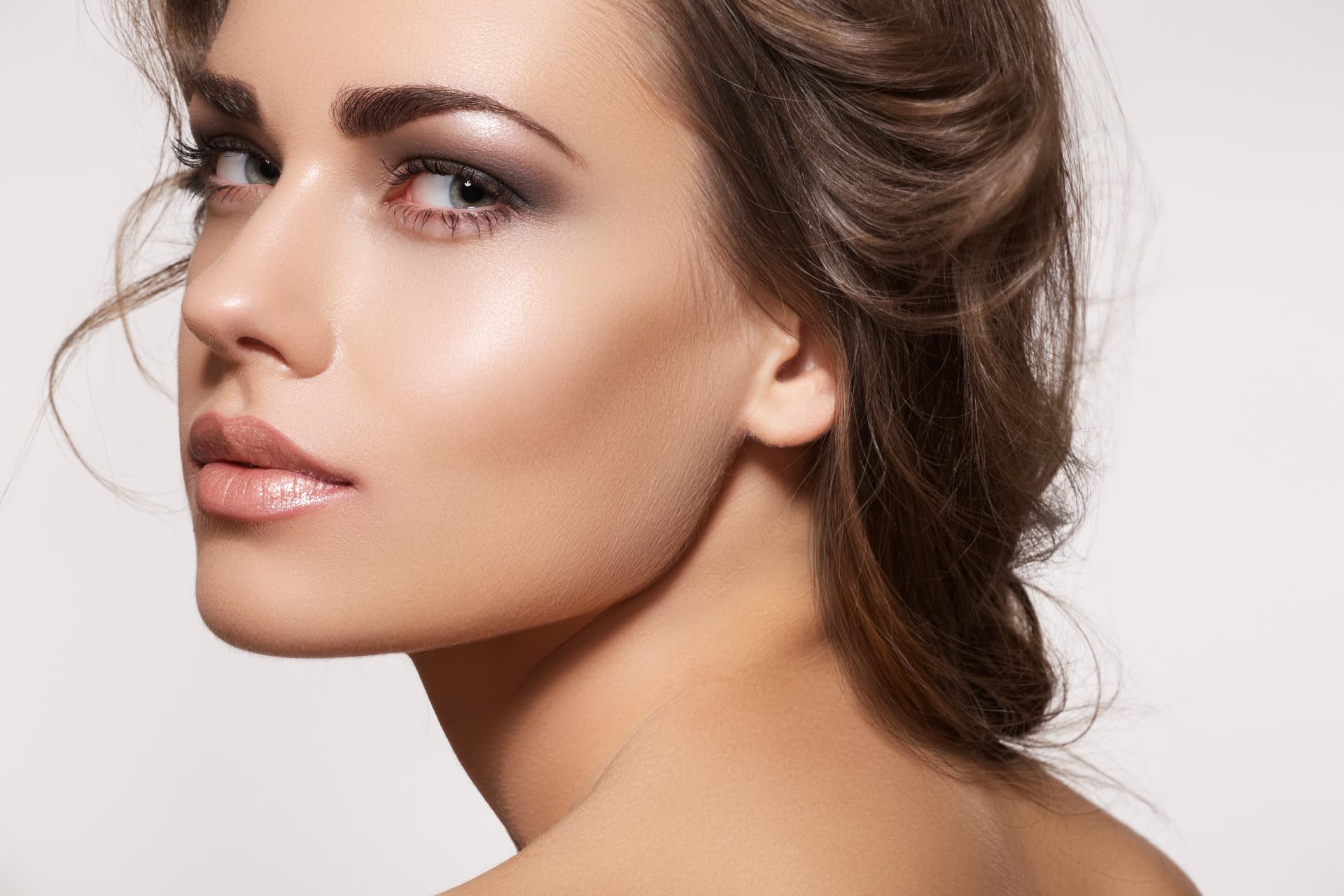 Beauty portrait of a woman with glowing skin and swept-back hair